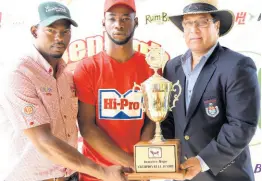  ??  ?? A Cayman official and a Hi-Pro representa­tive present a young farmer with the Champion Jamaica Hope Bull Junior Trophy.