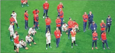  ??  ?? DECEPCIÓN. Los jugadores y el cuerpo técnico del Sevilla observan cómo el Barcelona recibe el trofeo.