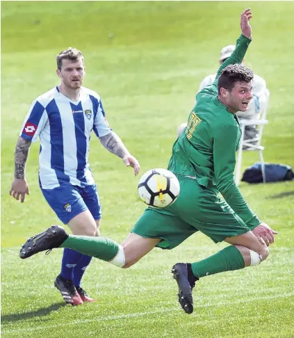  ?? PHOTO: PETER MCINTOSH ?? Well heeled . . Green Island player Matthew Brazier flicks the ball with his heel during the South Island championsh­ip match against Cashmere at Sunnyvale on Saturday. Cashmere player Sam Ford looks on.