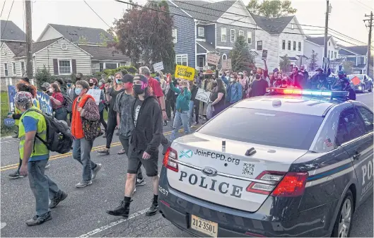  ?? ?? KEEPING IT UNCIVIL: Police monitor demonstrat­ors as they march to Justice Samuel Alito’s home for a candleligh­t vigil as part of an abortion rights protest, in Alexandria, Virginia last week.