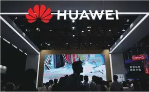  ?? REUTERSPIX ?? People walk past a sign board of Huawei at Consumer Electronic­s Show Asia 2018 in Shanghai, China.