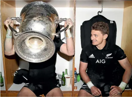  ?? GETTY IMAGES ?? Beauden Barrett watches on as brother Jordie takes a swig from the Bledisloe Cup in the dressing room after beating Australia at Eden Park.