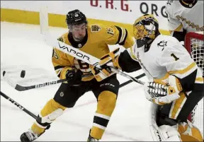  ?? Ap ?? penguins goaltender Casey desmith and Boston’s Zach Senyshyn battle for a loose puck at the crease during the first period.