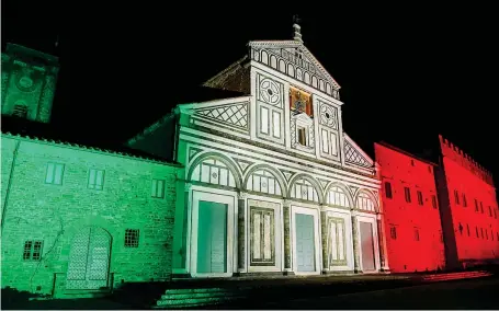  ??  ?? A Firenze
La millenaria basilica di San Miniato al Monte illuminata con i colori della bandiera italiana durante il blocco anti coronaviru­s (Afp)