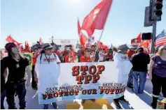  ??  ?? Protesters line one side of a roadway leading to Sunnylands where US President Obama prepares to host leaders from Southeast Asia at the ASEAN Summit in Rancho Mirage, California. — Reuters photo