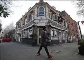  ?? FRANK AUGSTEIN — AP PHOTO ?? A man walks past the Duke of Sussex pub with a sign depicting the image of Britain’s Prince Harry and his wife Meghan, near Waterloo station, London.