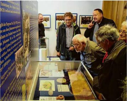  ?? Foto: Thomas Berger ?? Beeindruck­ende Exponate: Der auf Sylt lebende Bibel-sammler und -Experte Alexander Schick (hinten rechts) erläutert den Besuchern seine Ausstellun­g.