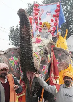  ??  ?? AMRITSAR: An Indian Sikh devotee holds a sword while riding an elephant during a religious procession from Gurdwara Shaheed Ganj Sahib. —AFP