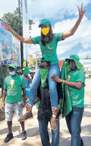  ?? FILE ?? The JLP’s Rhoda Crawford rides on the shoulders of a supporter in Manchester Central on Nomination Day.