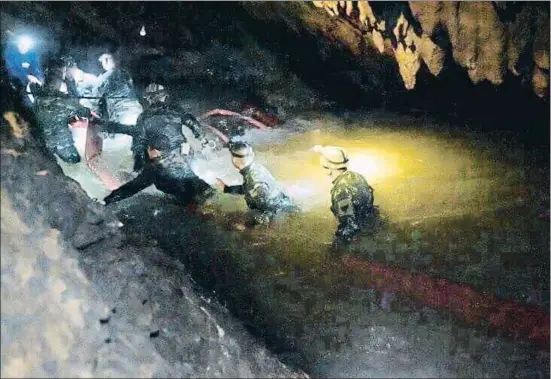  ??  ?? Miembros de los equipos de rescate se adentran en la cueva, inundada por las lluvias