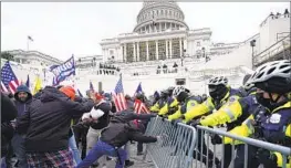  ?? Julio Cortez Associated Press ?? RIOTERS loyal to then-President Trump face off with police at the U.S. Capitol on Jan. 6, 2021. House Republican­s seek to undercut the select panel’s findings.