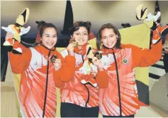  ??  ?? Sarawak’s Syafiqah (left), Joselyna (centre) and Nerosha show off their women’s trios gold medal at Megalanes. — Photo by Wilfred Pilo