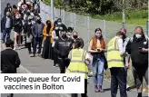  ??  ?? People queue for Covid vaccines in Bolton