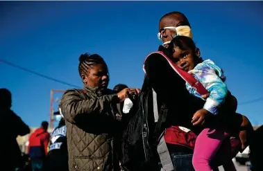  ?? STAFF PHOTOGRAPH­ER ?? Quettlie Fanfan, her husband, Domingue Paul, and daughter, Ruthshamma Paul Fanfan, 2, wait to get on a bus going from Ciudad Acuña, across from Del Rio, to the Mexican city of Torreón in hopes of finding housing and jobs.
