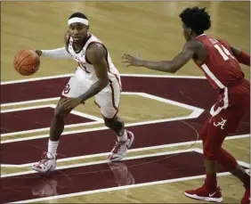  ?? GARETT FISBECK - THE ASSOCAITED PRESS ?? Oklahoma’s De’Vion Harmon (11) dribbles against Alabama’s Keon Ellis (14) during the second half of an NCAA college basketball game in Norman, Okla., Saturday, Jan. 30, 2021.