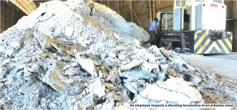  ??  ?? An employee inspects a shunting locomotive at an asbestos mine