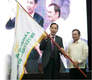  ?? PNA ?? DA turn over Outgoing Department of Agricultur­e (DA) Secretary Emmanuel Piñol (right), hands over the Flag of Leadership to incoming Secretary William Dar in a ceremony held at the Bureau of Soils and Water Management Convention Hall, Quezon City on 13 August 2019. Dar assured local farmers affected by the Rice Tarifficat­ion Law of cash assistance.