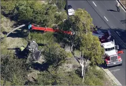  ?? MARK J. TERRILL — THE ASSOCIATED PRESS ?? A crane is used to lift a vehicle following a rollover accident involving golfer Tiger Woods on Tuesday in Rancho Palos Verdes.