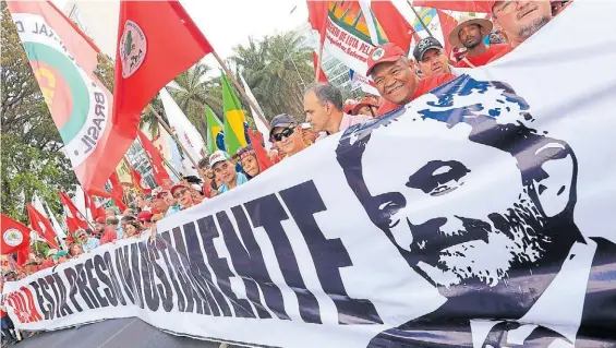  ?? EFE ?? Apoyo. Simpatizan­tes del ex presidente Lula da Silva sostienen un cartel durante una marcha ante la Justicia electoral en Brasilia.