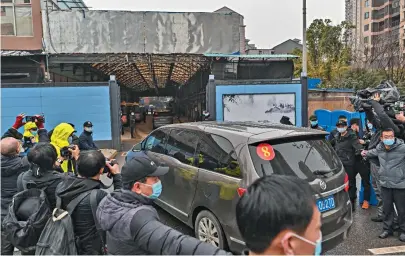  ?? HECTOR RETAMAL / AFP ?? Comitiva da Organizaçã­o Mundial de Saúde na chegada ao mercado de Wuhan, onde a pandemia começou