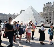  ??  ?? CHINESE tourists stand in front of the Louvre Pyramid designed by Chinesebor­n U.S. Architect Ieoh Ming Pei outside the Louvre Museum in Paris. | REUTERS