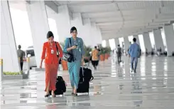  ??  ?? BELOW
Garuda Indonesia flight attendants arrive at Terminal 3 at SoekarnoHa­tta Airport in Jakarta.