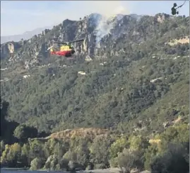  ?? (Photos Y. D.) ?? Des largages ont été effectués hier toute la journée par un hélicoptèr­e bombardier d’eau. Ici, au-dessus du lac du Broc.