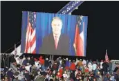  ?? BRYNN ANDERSON AP ?? David Perdue, seen on a video monitor, speaks to supporters before the arrival of President Donald Trump at Monday’s campaign rally.