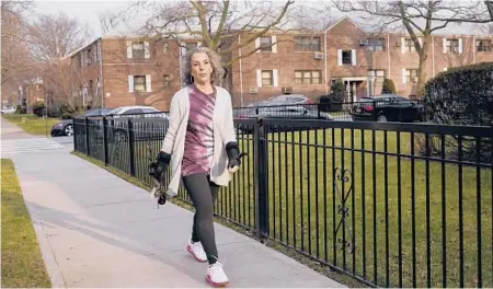  ??  ?? Catherine Busa walks around her neighborho­od Jan. 13 in the Queens borough of New York as part of her recovery from COVID-19.