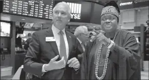  ?? AP/RICHARD DREW ?? King Michael Odunayo Ajayi of Nigeria’s Osun state is escorted Monday by Jim Byrne, the New York Stock Exchange’s head of U.S. listings, during a visit to the trading floor.