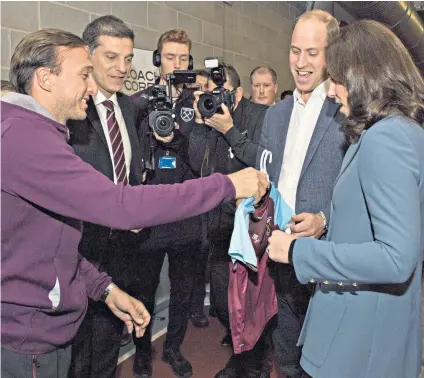  ??  ?? Royal patrons: West Ham’s Mark Noble (left) hands over a replica kit to the Duke and Duchess of Cambridge