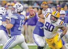  ?? THE ASSOCIATED PRESS ?? LSU defensive end Rashard Lawrence closes in on BYU quarterbac­k Tanner Mangum during last September’s 27-0 win by the Tigers.