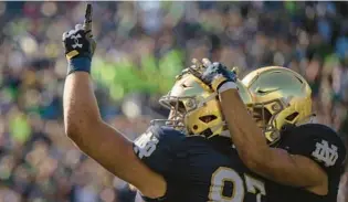  ?? MARC LEBRYK/AP ?? Notre Dame tight end Michael Mayer, left, celebrates a touchdown reception with wide receiver Braden Lenzy during the first quarter against UNLV on Saturday in South Bend, Ind.