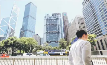  ??  ?? A man walks along the financial central district in Hong Kong, China. China’s banking regulator will further tighten the screws on the trust industry next year, as Beijing steps up a campaign to clampdown on the country’s shadow banking sector. –...