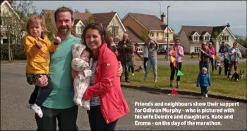 ??  ?? Friends and neighbours show their support for Odhrán Murphy – who is pictured with his wife Deirdre and daughters, Kate and Emma – on the day of the marathon.