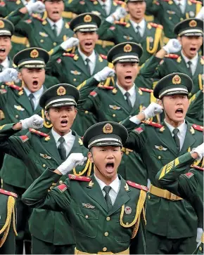  ?? GETTY IMAGES ?? Soldiers of Beijing Armed Police Force salute to the Chinese Communist Party flag before a gun salute training exercise.