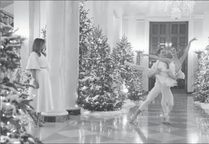  ?? OLIVIER DOULIERY, TNS ?? First Lady Melania Trump watches ballerinas perform in a White House hallway as part of this year’s holiday celebratio­ns.