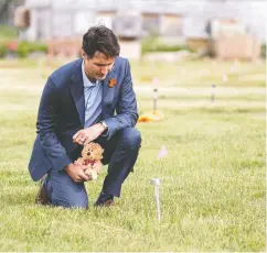  ?? LIAM RICHARDS / POOL VIA REUTERS FILES ?? Prime Minister Justin Trudeau leaves a teddy bear near a small flag at the site of a former residentia­l school,
something Melissa Mbarki found “infuriatin­g.”