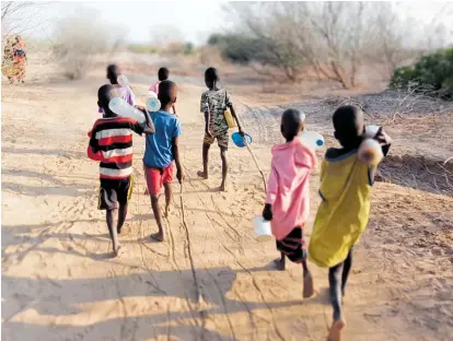  ?? PHOTO / LIZA CRONHELM ?? Walking to El Bokoch School carrying water and firewood.