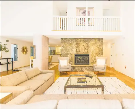  ?? Coldwell Banker Residentia­l Brokerage ?? The living and dining areas at 13A Dogwood Lane in Westport feature soaring ceilings, skylights, hardwood floors and a stone fireplace.