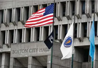  ?? AP PHOTO/CHARLES KRUPA ?? The American flag, the Commonweal­th of Massachuse­tts flag, and the City of Boston flag fly outside Boston City Hall, Monday, May 2, 2022, in Boston.