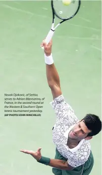  ?? (AP PHOTO/JOHN MINCHILLO) ?? Novak Djokovic, of Serbia, serves to Adrian Mannarino, of France, in the second round at the Western &amp; Southern Open tennis tournament yesterday.