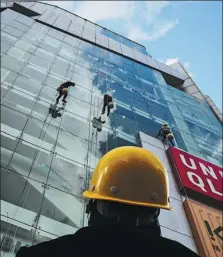  ?? YE YONG / FOR CHINA DAILY ?? “Spidermen” clean the glass windows of a shopping mall in Kunming, Yunnan province, in December.