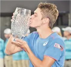  ??  ?? Australia's Alex De Minaur kisses the trophy after beating Andreas Seppi of Italy in the men's final match at the Sydney Internatio­nal tennis tournament in Sydney. - AFP photo