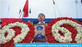  ??  ?? YANGON: A student holds a portrait of General Aung San during a ceremony to mark the 30th anniversar­y of the 8888 uprising in front of city hall. — AFP