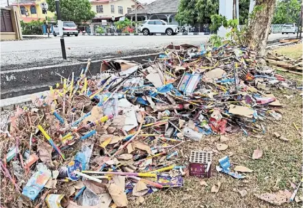  ?? ?? Unsightly mound: piles of fireworks packaging and debris left behind on a football field and near drains at Kampung Jalan daud in Muar.