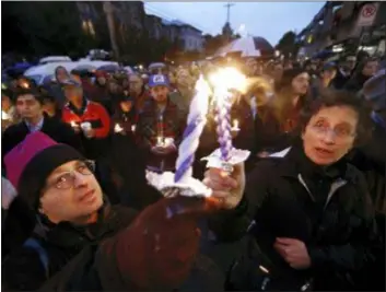  ?? MATT ROURKE - THE ASSOCIATED PRESS ?? People light candles as they gather for a vigil in the aftermath of a deadly shooting at the Tree of Life Congregati­on, in the Squirrel Hill neighborho­od of Pittsburgh, Saturday.