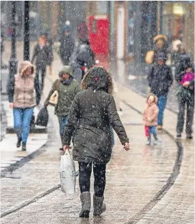  ??  ?? Snow continues to melt away as sleet falls in the city centre.