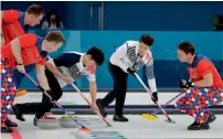  ?? AP ?? Action from a men’s curling match at the Games. —