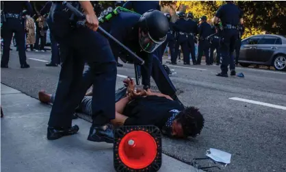  ??  ?? A police officer arrests a man during a protest demanding justice for George Floyd and Breonna Taylor in Downtown Los Angeles. Photograph: Apu Gomes/AFP/Getty Images